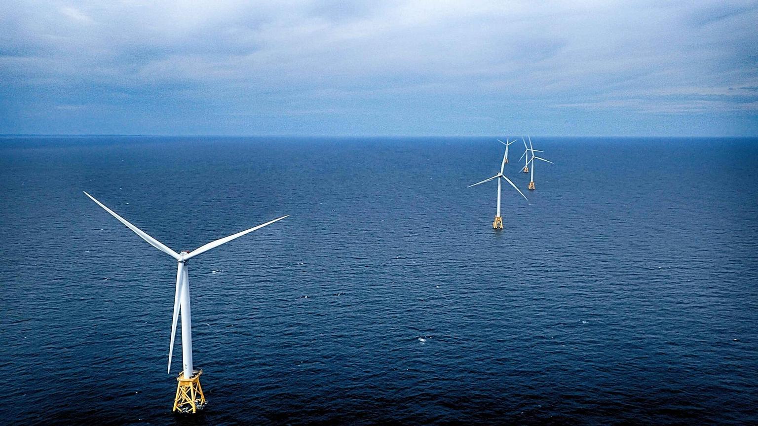 Five offshore wind turbines in a line at Block Island Wind Farm, viewed from the air