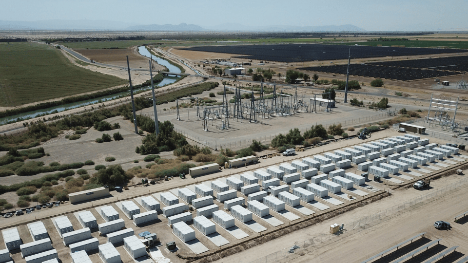 Rows of white grid-scale battery enclosures at the Calexico energy storage facility in California beside high-voltage equipment.