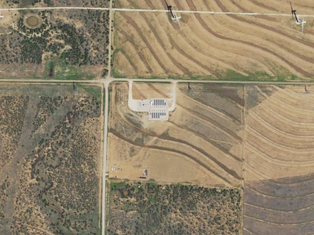 Aerial view of the Endurance Park site: a storage/substation pad amid farmland with wind turbines nearby.