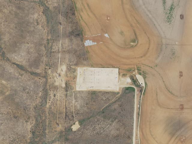 Aerial view of the Lumina II site: a light-colored equipment pad set among plowed West Texas farm fields.