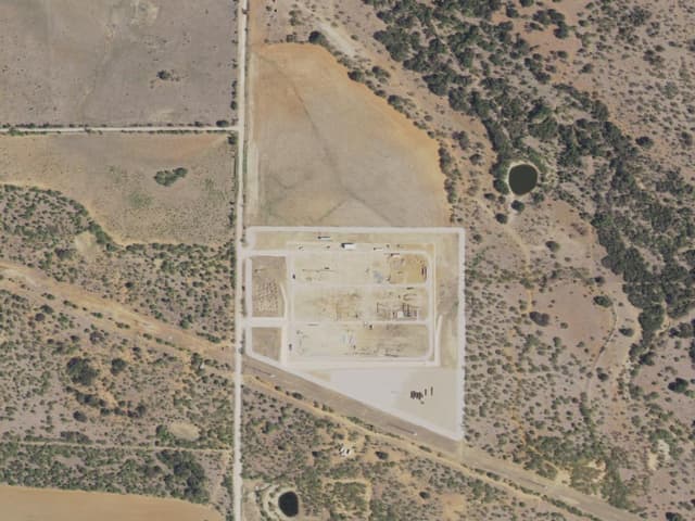 Aerial view of the Roadrunner Crossing site: a large equipment pad beside cultivated fields in West Texas.